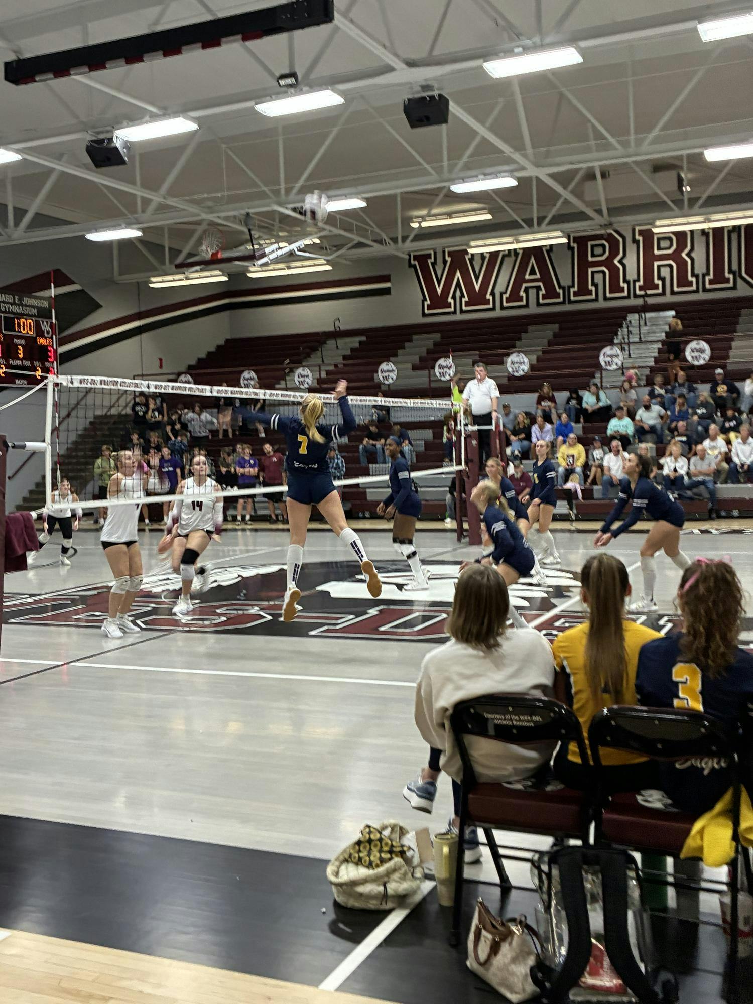 A Delta player serves during the second set as coaches and teammates look on. The Eagles’ consistent serving runs built early leads that carried them to victory over Wes-Del.
