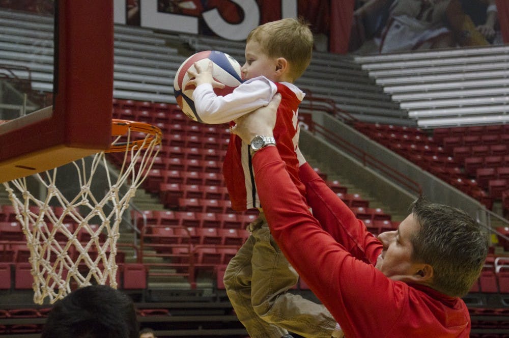 Intermin Athletic Director Brian Hardin lifts up his son, Noah Hardin, 3, at the Winter Fan Jam on Jan. 4 at Worthen Arena. DN PHOTO BREANNA DAUGHERTY
