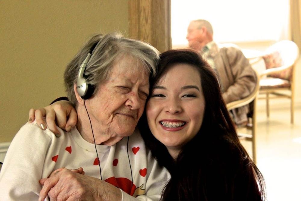 Athena Nagel, a Music & Memory volunteer, hugs Ruth Pierce, a Muncie nursing home resident while she listens to music on an iPod. Music and Memory, Photo Provided