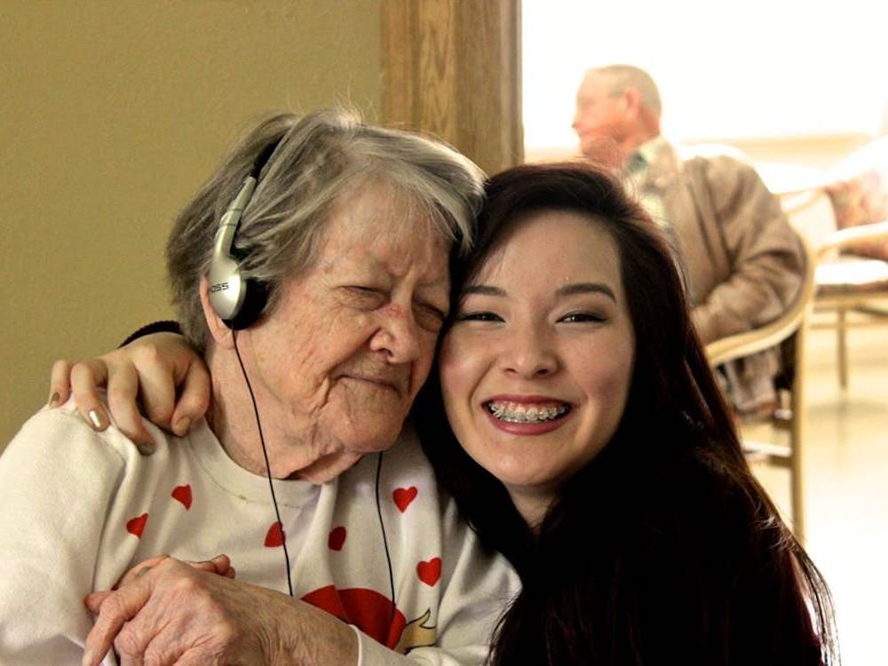  Athena Nagel, a Music & Memory volunteer, hugs Ruth Pierce, a Muncie nursing home resident while she listens to music on an iPod. Music and Memory, Photo Provided