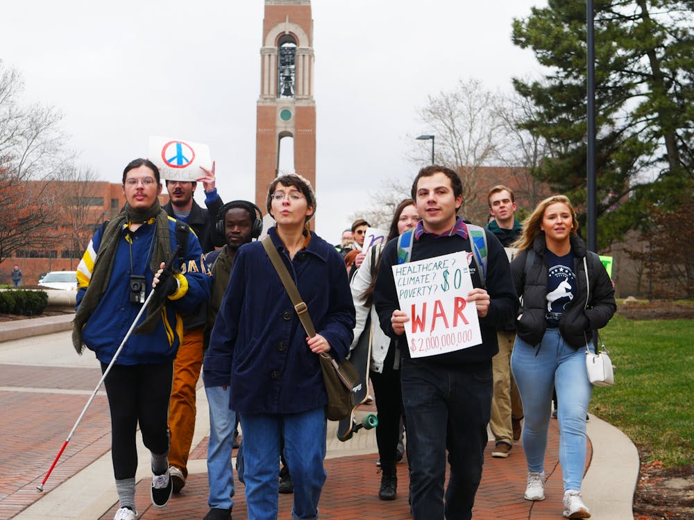 Ball State students hold signs and march Jan. 13, 2020, down McKinley Avenue for an anti-war protest. The protest was held by Ball State Democrats. Jake Helmen, DN&nbsp;