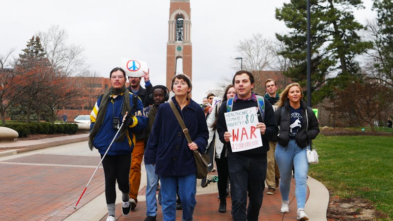 Ball State students hold signs and march Jan. 13, 2020, down McKinley Avenue for an anti-war protest. The protest was held by Ball State Democrats. Jake Helmen, DN&nbsp;