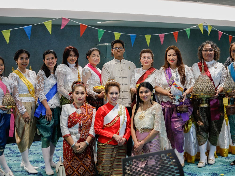 Members of the Royal Thai Consulate pose for a photo with Sakdidach (Joseph) Nobpatsorn (center) at the Songkran festival April 12 at Emens Auditorium. Nobpatsorn is the president of Global Harmony student organization. Andrew Berger, DN