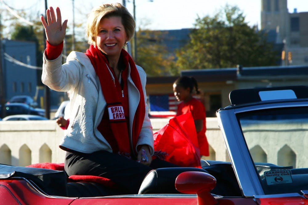  Ball State President Jo Ann Gora waves to the crowd at the Homecoming Parade on the morning of Oct. 12. Muncie Mayor Dennis Tyler also was in the parade. DN PHOTO TAYLOR IRBY