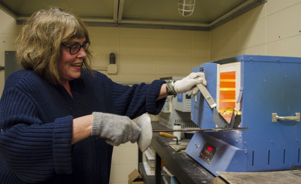 Patricia Nelson creates a piece of vitreous enamel on Oct. 16. Vitreous enamel is made from powdered glass. DN PHOTO BREANNA DAUGHERTY