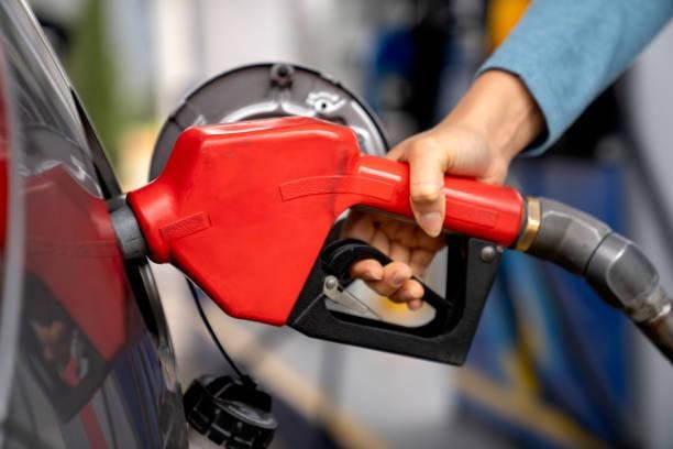 Close-up on a woman refueling her car at a gas station and holding a fuel pump. Getty Images/Indiana Capital Chronicle)