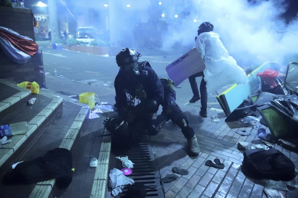 <p>A policeman in riot gear detains a protester outside of Hong Kong Polytechnic University as police storm the campus in Hong Kong, early Monday, Nov. 18, 2019. Fiery explosions were seen early Monday as Hong Kong police stormed into a university held by protesters after an all-night standoff. <strong>(AP Photo/Kin Cheung)</strong></p>