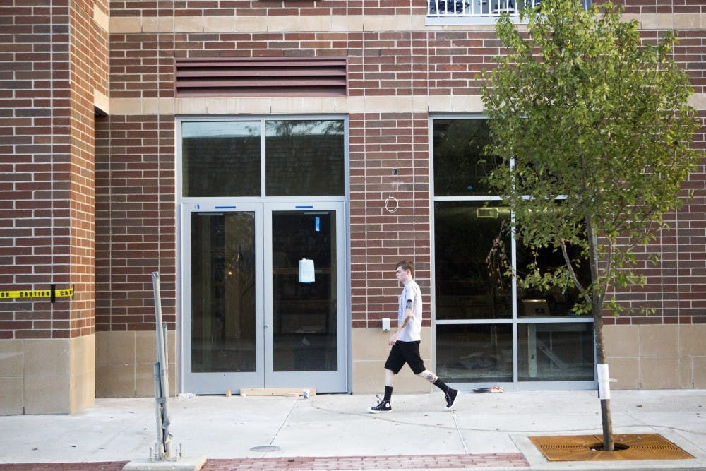 A pedestrian walks past store fronts at the Village Promenade on Sept. 1. There are four confirmed businesses going into the Village Promenade. DN PHOTO JORDAN HUFFER
