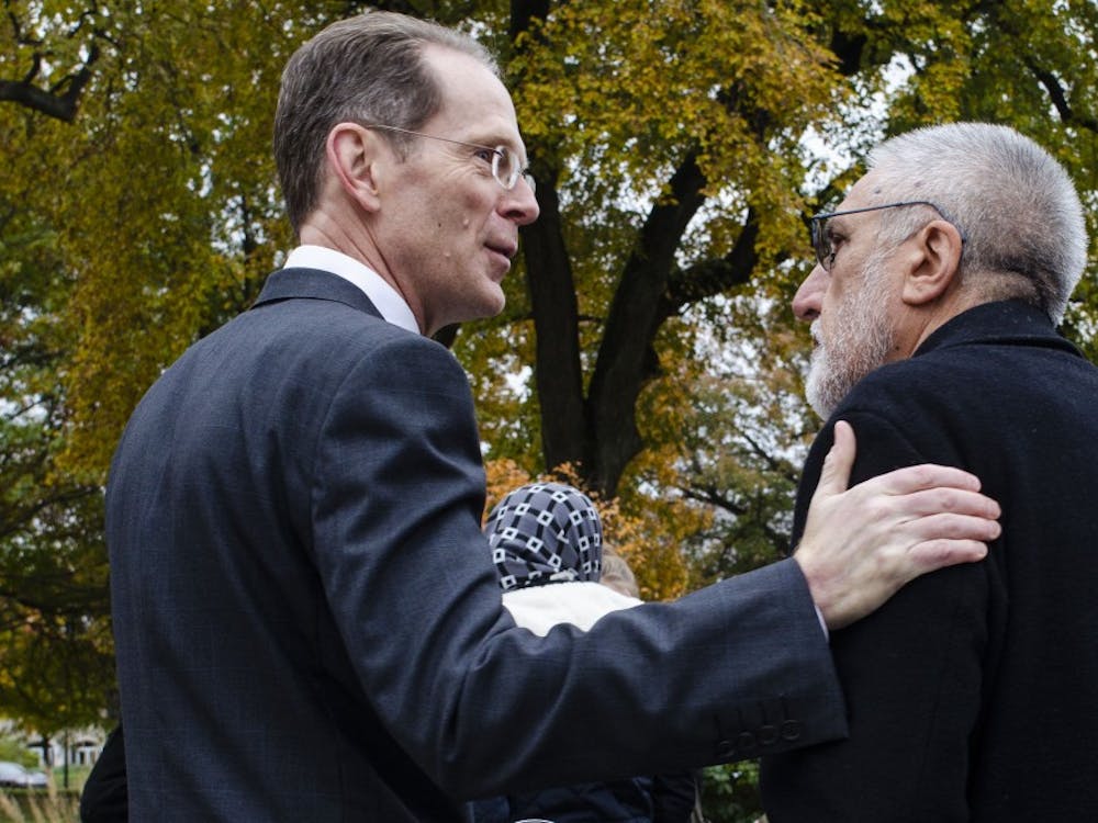 President Geoffrey Mearns thanks Mohammad Saber Bahrami, family physician at Indiana University Health, for attending the vigil at Beneficence Statue was surrounded with people with candle sticks and a memorial speeches, Nov. 2, 2018.  Stephanie Amador, DN