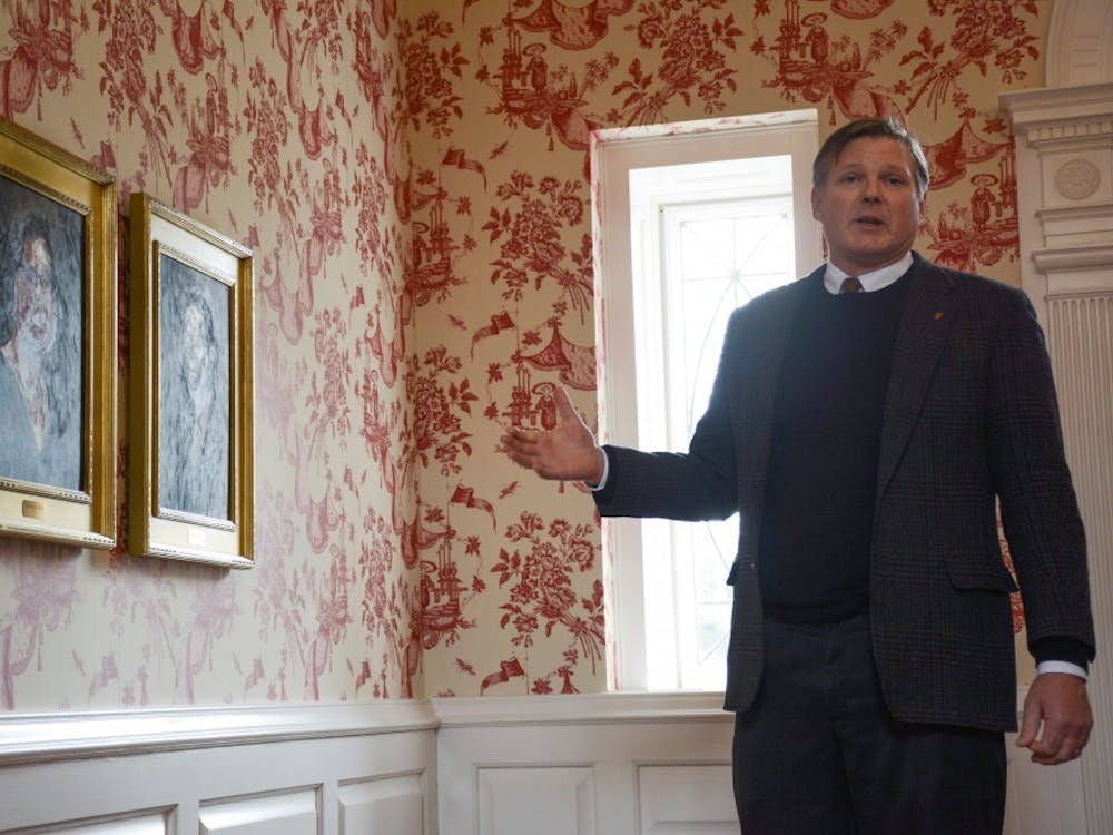 Tom Bracken's gestures to two portraits of his grandparents that used to live in the Bracken House. Bracken is running as a Republican in this upcoming Muncie mayor election. Kaiti Sullivan, DN 