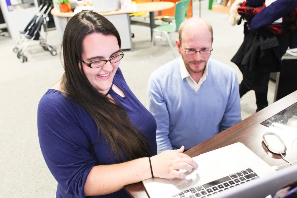  Lacey Lord, a member of the Ball State team, looks at a computer with Ansgar Snetlage at the Dresden Military Museum. Snetlage was of the first people they met in Dresden, Germany. 