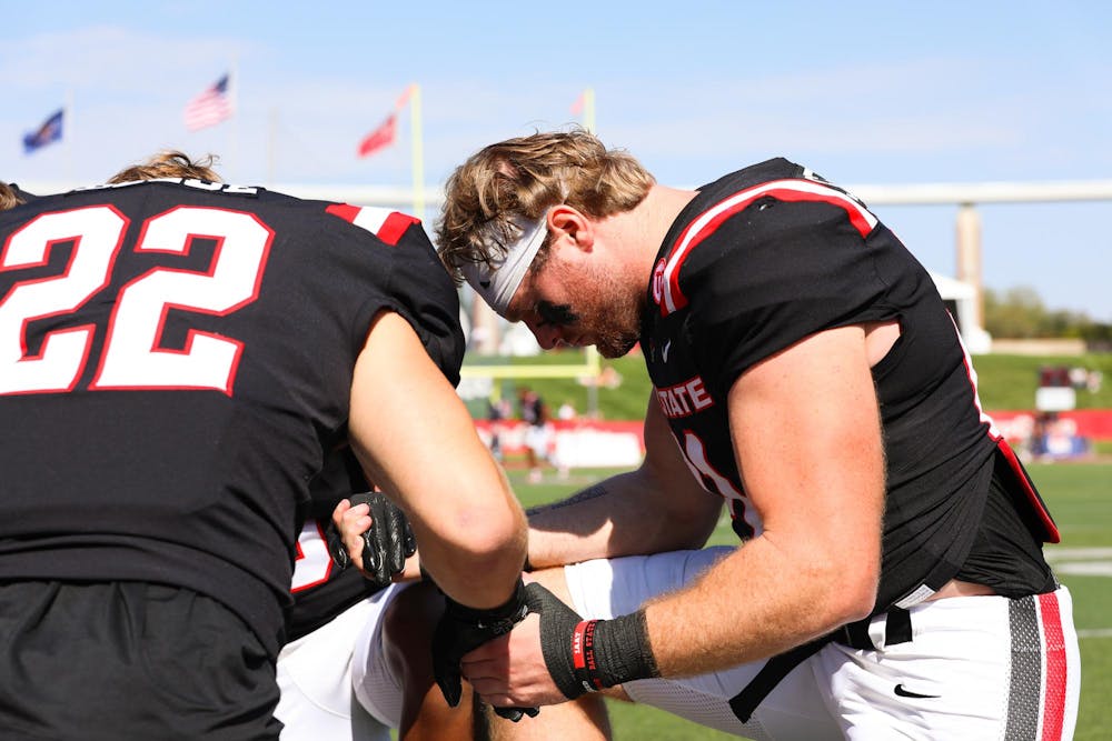 A group of Ball State players pray before the game Oct. 5 at Scheumann Stadium. Ball State lost to Western Michigan 45-42. Isabella Kemper, DN