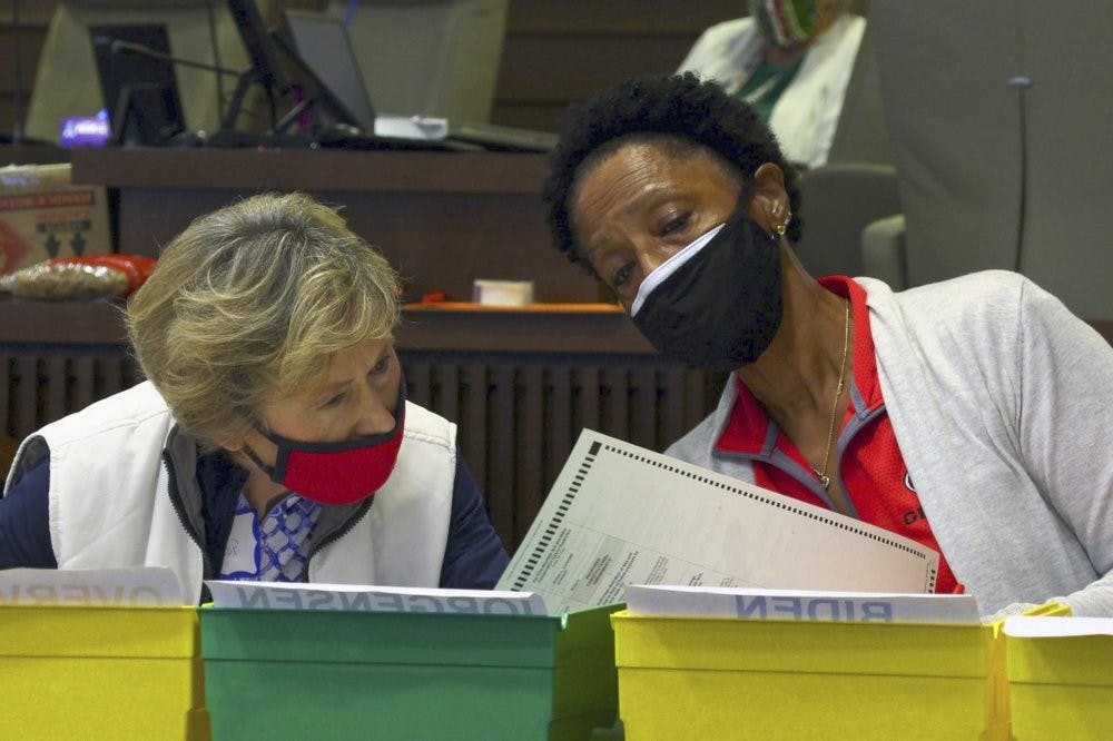 Bipartisan teams of Democrats and Republicans work on an audit of Friday, Nov. 13, 2020, in Council Chambers at the City Services Center, in Columbus, Ga. Election officials in Georgia's 159 counties started counting ballots Friday morning for a hand tally of the presidential race that stems from an audit required by state law. (Mike Haskey/Ledger-Enquirer via AP)