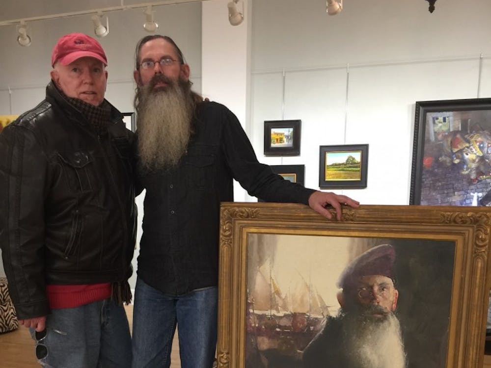 C. W. Mundy (left) poses with Richard Anderson (right)&nbsp;next to Mundy's portrait of Anderson.&nbsp;