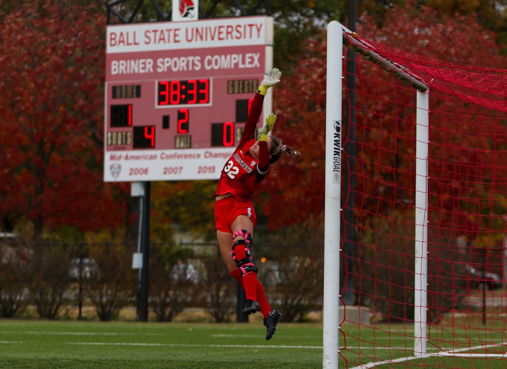 <p>Second-year goalkeeper Bethany Moser in the air after successfully blocking a shot taken on Ball States goal in the second half of the game against Akron on Oct. 13 at Briner Sports Complex. Moser had a total of three saves during the match. Eve Green, DN</p>