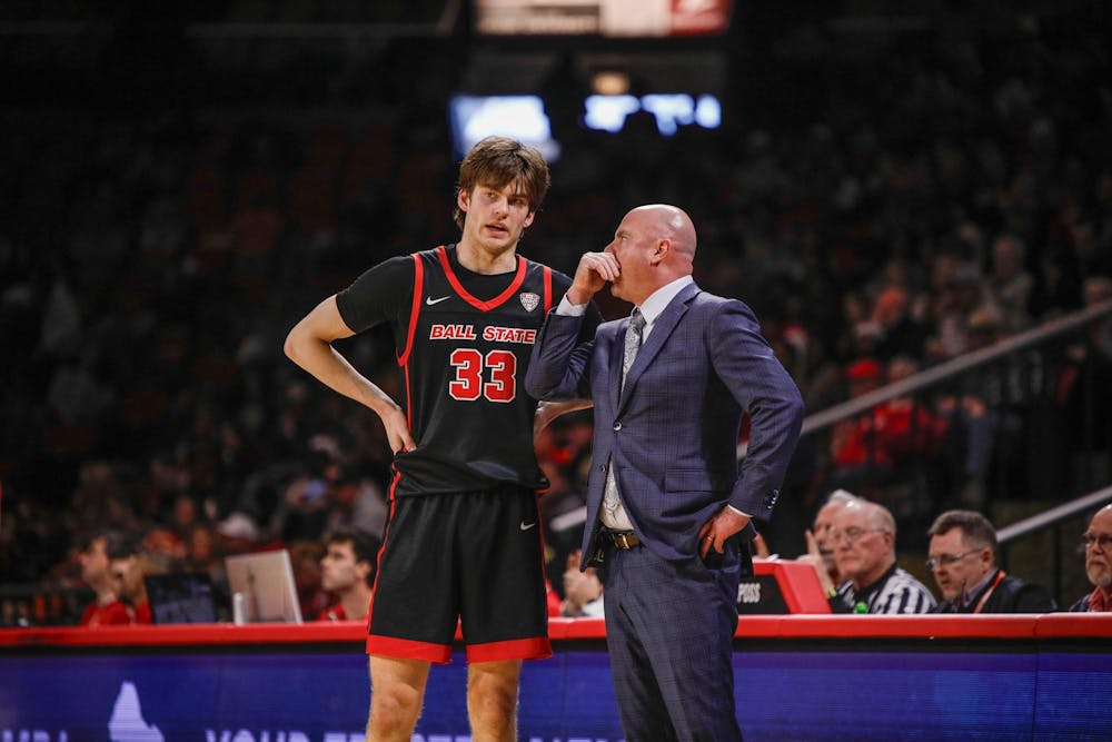 <p>Freshman guard Mason Jones talks to coach Micheal Lewis during a free throw against Miami Feb. 17 at Millet Hall. Jones had two total points in the game. Andrew Berger, DN </p>