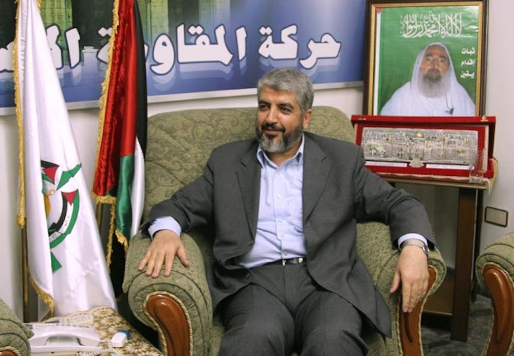 Khaled Mashaal, the Hamas political leader in exile, speaks to a reporter during an exclusive interview in his office in Damascus, Syria, August 21, 2007. Behind him is a poster featuring Sheik Ahmad Yassin, a founder of Hamas who was assassinated by Israel in 2004. (Dion Nissenbaum/MCT)