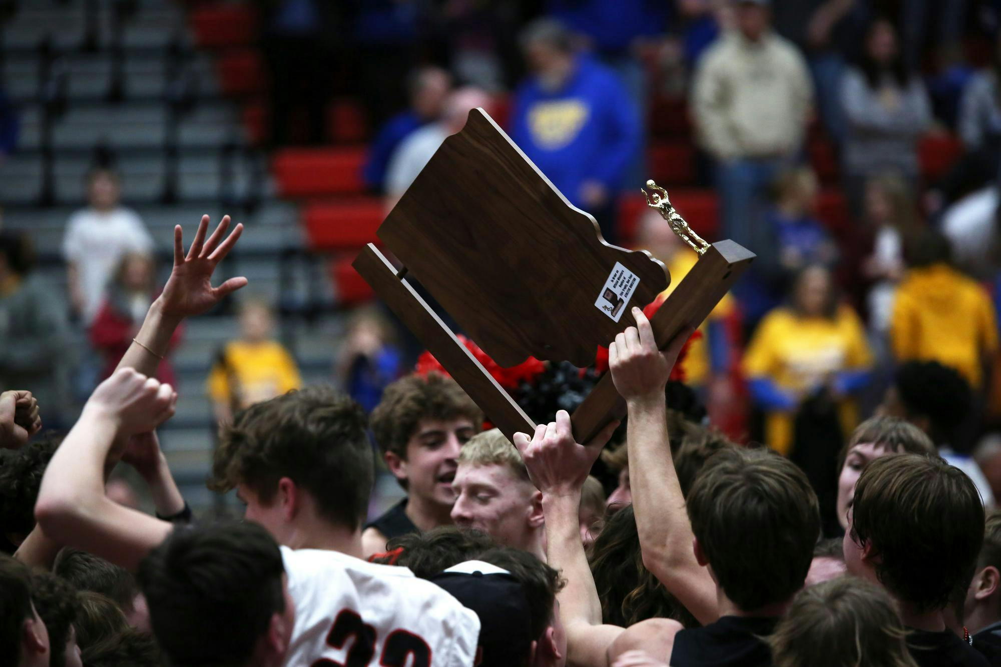 A Wapahani boys' basketball player holds the 2A semistate trophy March 16 after a game against Fort Wayne Christian Blackhawk at Lafayette Jefferson High School. It is the first semistate title in program history. Zach Carter, DN.