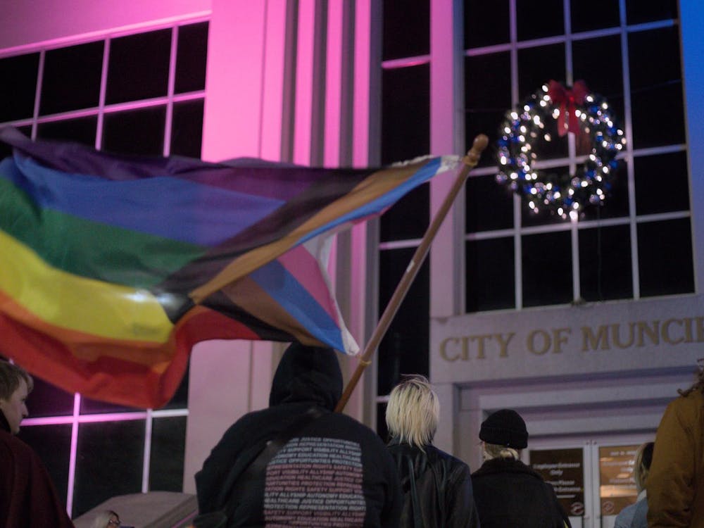 Beth McCollum listens to a speaker at City Hall, November 11th, 2024. City Hall is illuminated by lights matching the Transgender Pride Flag. Jeffrey Dreyer, DN