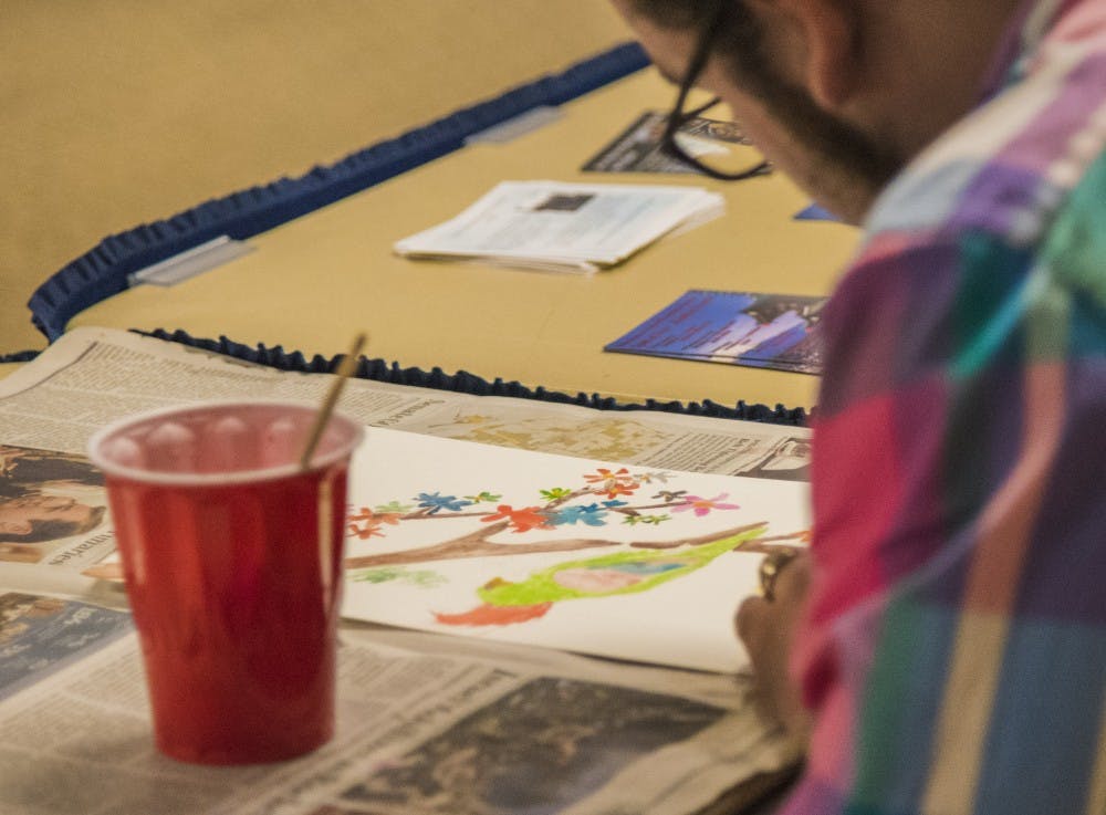 Hunter Sully, a graduate student, paints a water color of a parrot. The Asian American Student Association held the water painting event as part of their month of events. DN PHOTO RACHEL BRAMMER