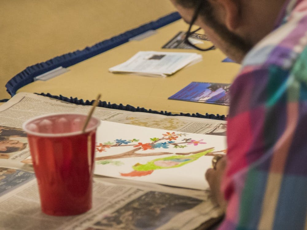 Hunter Sully, a graduate student, paints a water color of a parrot. The Asian American Student Association held the water painting event as part of their month of events. DN PHOTO RACHEL BRAMMER