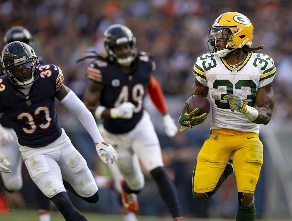Packers running back Aaron Jones (33) scores a touchdown against Bears cornerback Jaylon Johnson in the third quarter Sunday at Soldier Field. The Packers won 38-20.