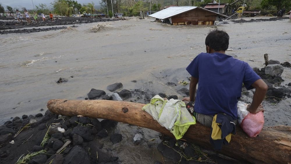 A man looks as floodwaters inundate an area as Typhoon Goni hit Daraga, Albay province, central Philippines, Sunday, Nov. 1, 2020. The super typhoon slammed into the eastern Philippines with ferocious winds early Sunday and about a million people have been evacuated in its projected path, including in the capital where the main international airport was ordered closed. (AP Photo)
