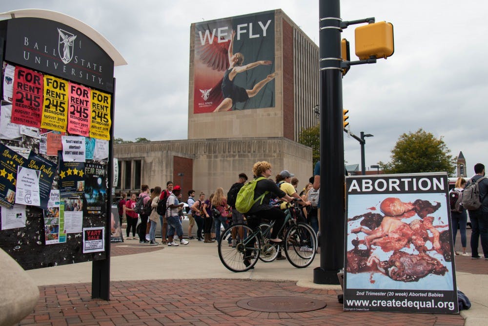 An anti-abortion group, Created Equal, displays signs and pictures Oct. 2, 2018, at the Scramble Light. Created Equal is traveling to 21 college campuses throughout October to showcase abortion and begin a conversation between students on campuses. Eric Pritchett, DN