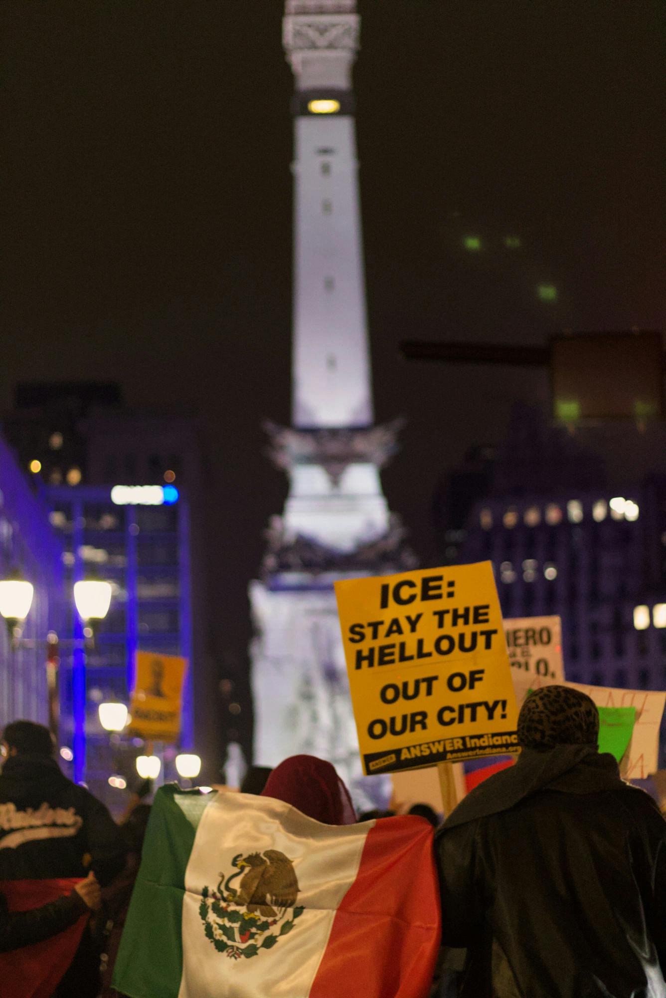 Protesters march towards Memorial Circle, carrying a Mexican flag and a sign reading, &quot;ICE: stay the hell out of our city!&quot; Jan 30th 2025 at Memorial Circle. Some protesters wore Mexican, Salvadoran, or Honduran flags around their necks. Jeffrey Dreyer, DN