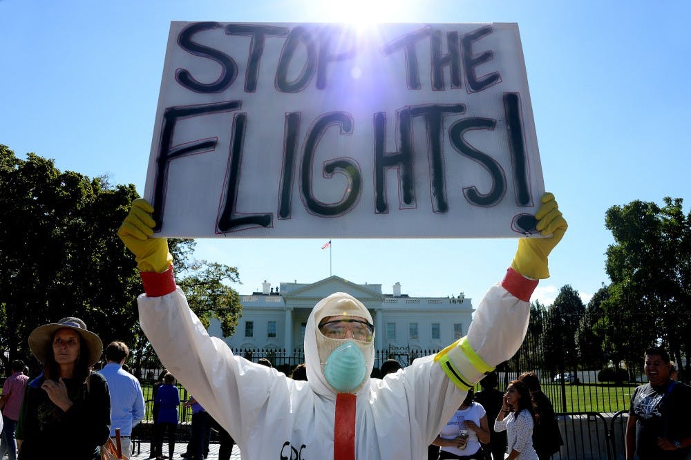 A protester stands outside the White House asking President Obama to ban flights in effort to stop Ebola, the deadly epidemic that has already reached American soil, on October 17, 2014 in Washington, D.C. The debate surrounding travel bans as a way to curb the spread of Ebola has intensified after Thursday's congressional hearing, unleashing a flurry of impassioned arguments on both sides. (Olivier Douliery/Abaca Press/MCT) 