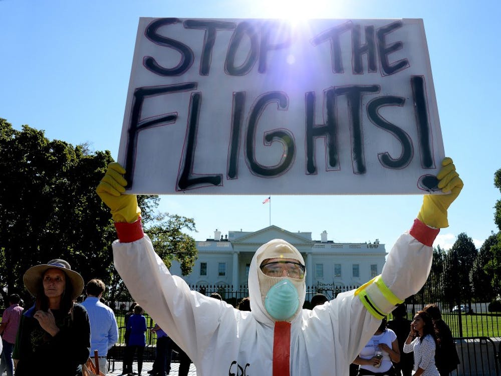 A protester stands outside the White House asking President Obama to ban flights in effort to stop Ebola, the deadly epidemic that has already reached American soil, on October 17, 2014 in Washington, D.C. The debate surrounding travel bans as a way to curb the spread of Ebola has intensified after Thursday's congressional hearing, unleashing a flurry of impassioned arguments on both sides. (Olivier Douliery/Abaca Press/MCT) 
