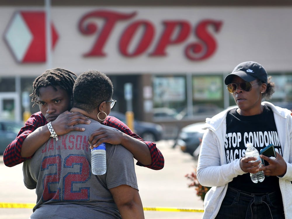 CREDIT: Tribune News Service- People gathered outside of Tops market embrace on May 15, 2022 in Buffalo, New York. Yesterday a gunman opened fire at the store, killing ten people and wounding another three. Suspect Payton Gendron was taken into custody and charged with first degree murder. (Scott Olson/Getty Images/TNS)