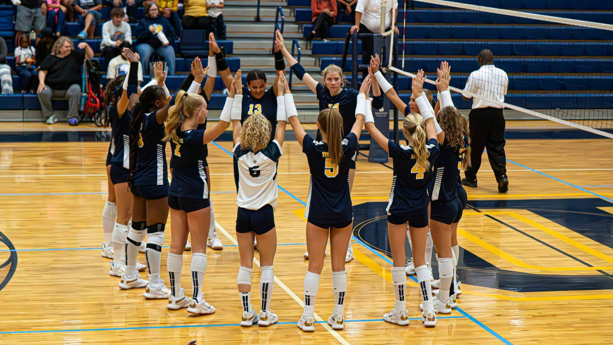 Delta makes a circle and holds hands high before their match against Pendleton Heights on Sept. 9. Delta would go on to win in five sets. PHOTO BY NICK WILSON
