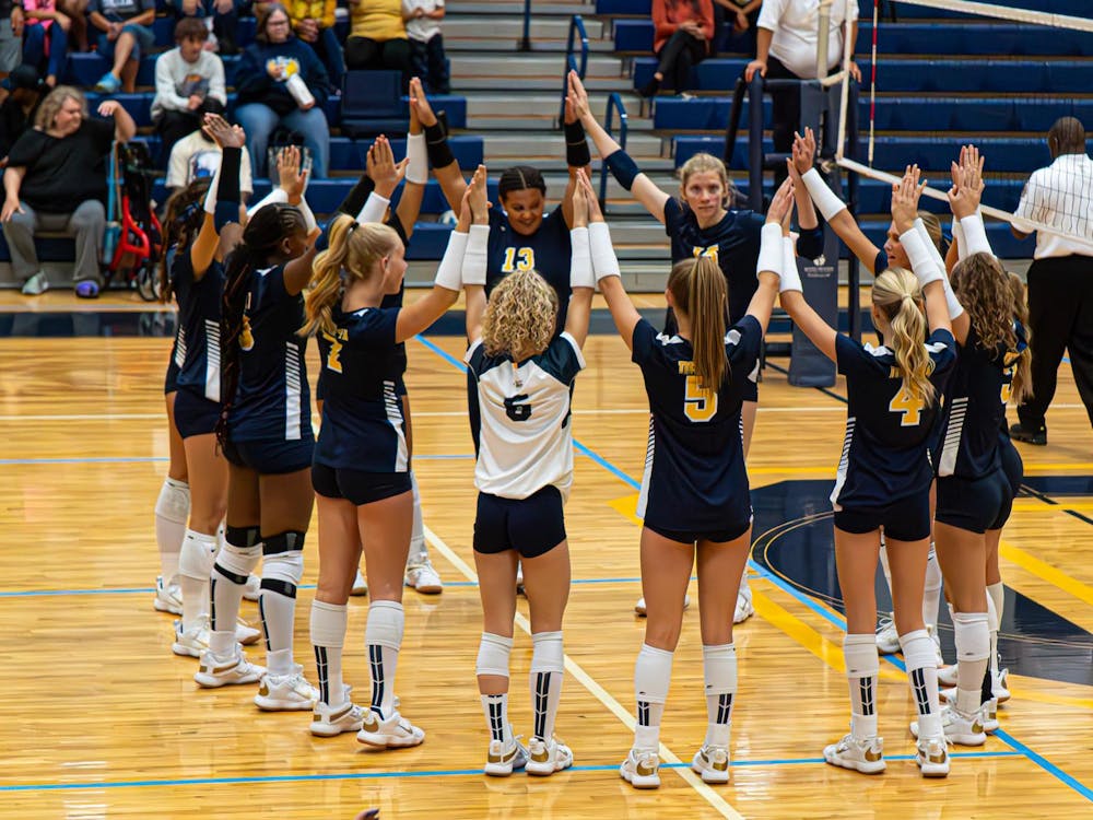 Delta makes a circle and holds hands high before their match against Pendleton Heights on Sept. 9. Delta would go on to win in five sets. PHOTO BY NICK WILSON