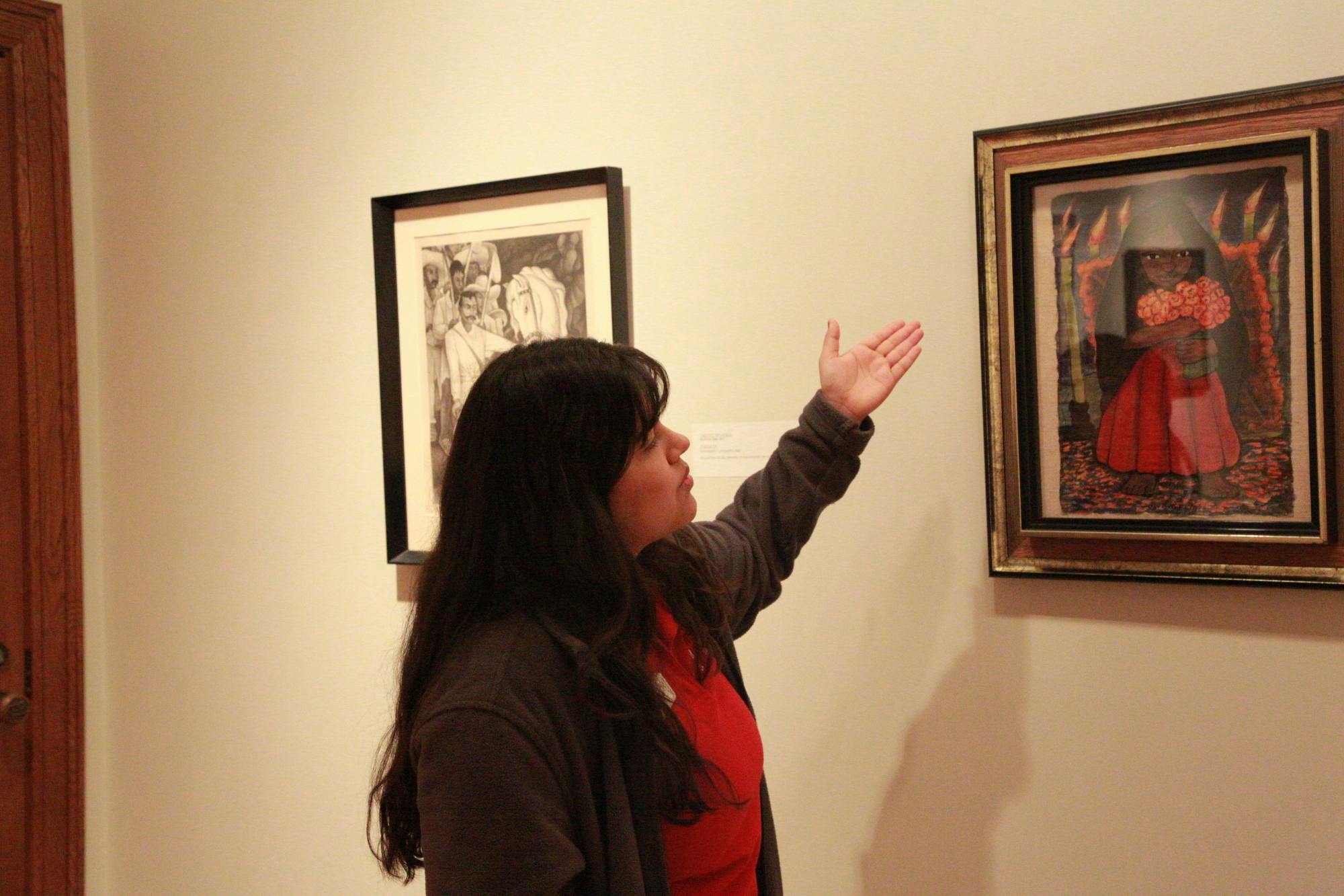 Jasmine Romero, museum docent, explains the details of artist Diego Rivera's "Niña con flores" Feb. 23, 2020. Romero pointed out the candles and flowers in the watercolor painting as inspired by the traditionally Hispanic day of remembrance Día de los Muertos. Brooke Kemp, DN