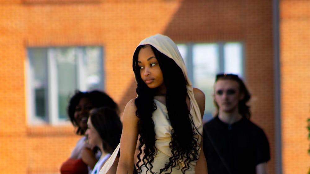 A model walking down the runway at the Brown Family Amphitheater on April 6, 2024. She is looking at the audience while down the stairs of the Brown Family Amphitheater. (Aaliyah Sansone, Photo Provided)
