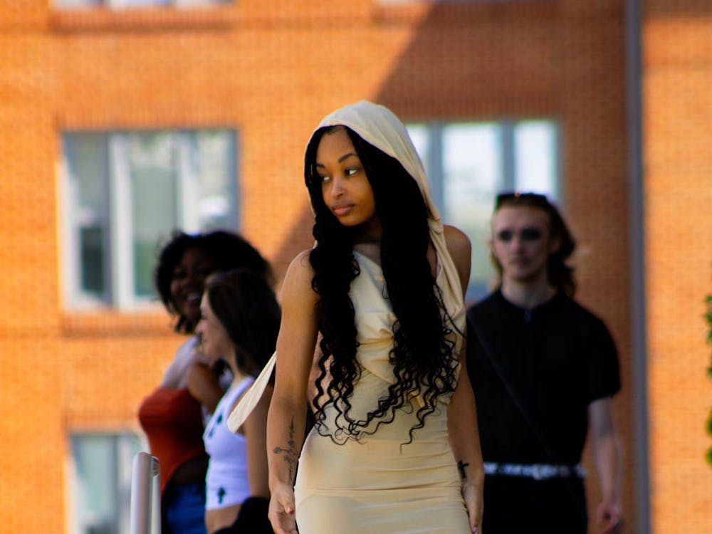A model walking down the runway at the Brown Family Amphitheater on April 6, 2024. She is looking at the audience while down the stairs of the Brown Family Amphitheater. (Aaliyah Sansone, Photo Provided)
