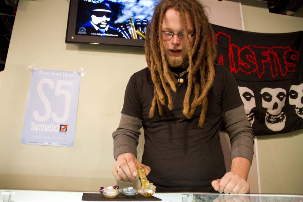 Jacob Price, a Ball State senior and manager of 420 Underground, talks about some locally made pipes at the smoke shop. 420 Underground, named after its address at 420 N. Martin St., is a shop in the Village where students can buy tobacco products. DN PHOTO EMMA FLYNN