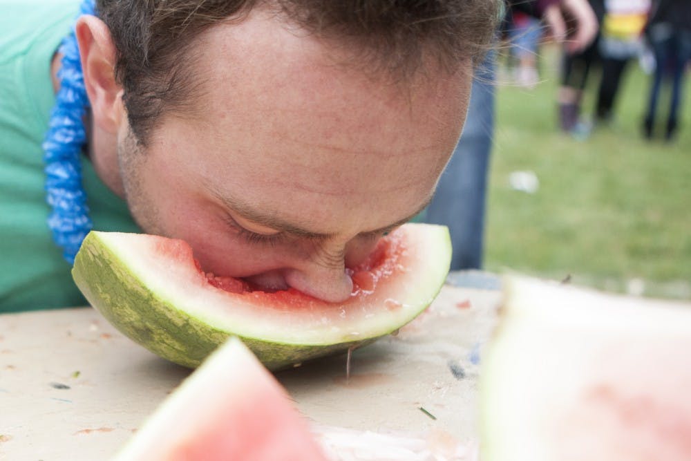 Senior computer technology major Matt Collison buries his face into a wedge of watermelon at the annual Watermelon Bust on Oct. 4. DN PHOTO JORDAN HUFFER