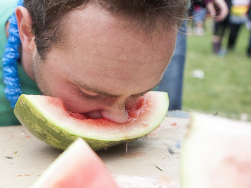 Senior computer technology major Matt Collison buries his face into a wedge of watermelon at the annual Watermelon Bust on Oct. 4. DN PHOTO JORDAN HUFFER