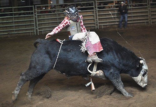 Jake Doll holds onto the bull rope with one hand while riding a bull at the Henry County Saddle Club February 28, 2012. The rodeos will only be offered for limited time due to a recent accident. DN FILE PHOTO MARIA STRAUSS
