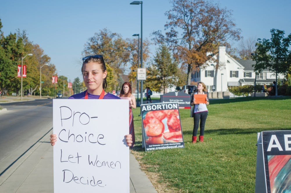 <p>Feminists for Action were at the Scramble Light on Oct. 20 with posters expressing their pro-choice beliefs so that students could see both sides of the abortion argument. <em>DN PHOTO BREANNA DAUGHERTY</em></p>