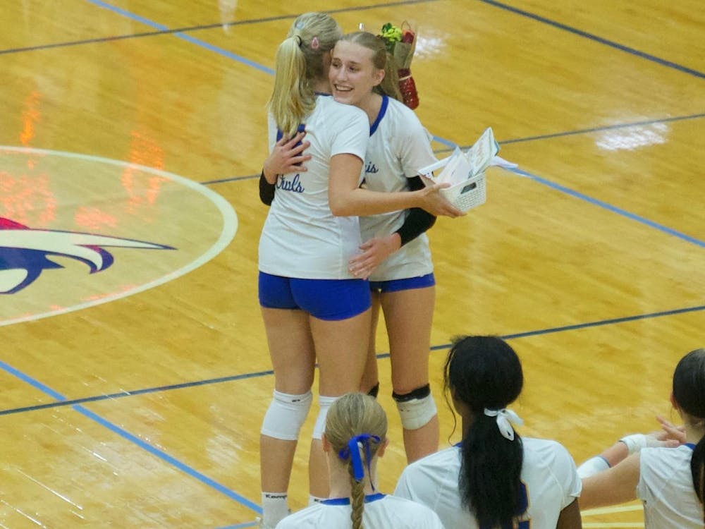 The Owls and junior setter/opposite hitter Addi Pierce (#3) recognize senior setter Klara Gelzer (#16) with a surprise presentation of flowers before the match. Burris went on to win in straight sets over Frankton, improving their overall record to 15–4. Photo by BRODRICK GOOD.