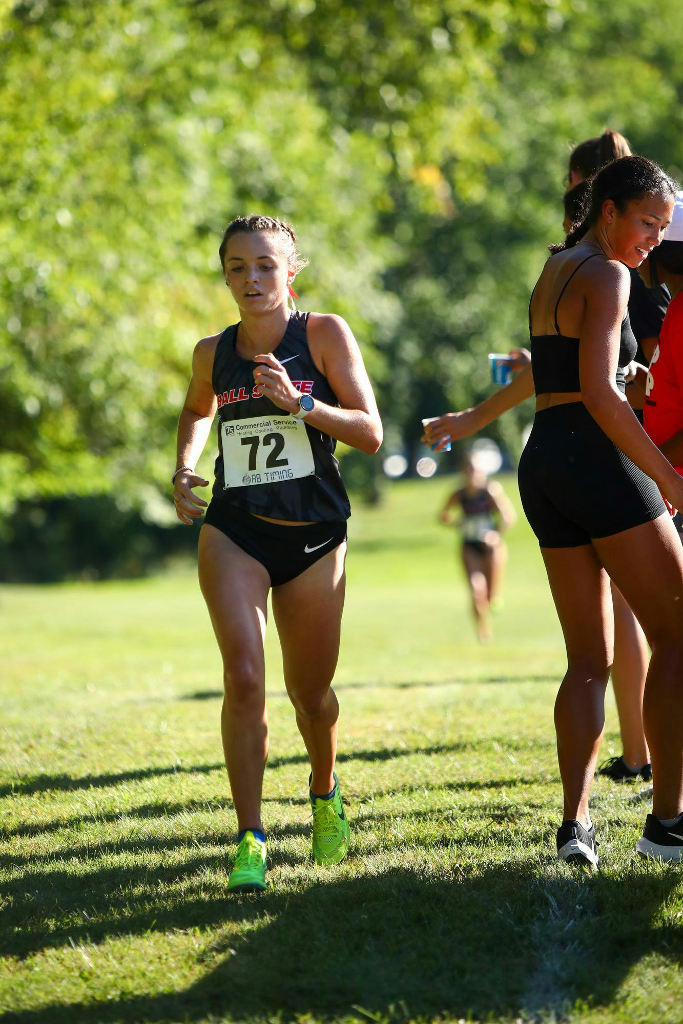 Junior Sarah Mahnensmith running through the water station of the 5k run at the We Fly Ball State Invitational Sept. 1. Mahnensmith finished third with a 18:43.0 time. Daniel Kehn, DN