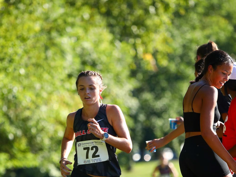 Junior Sarah Mahnensmith running through the water station of the 5k run at the We Fly Ball State Invitational Sept. 1. Mahnensmith finished third with a 18:43.0 time. Daniel Kehn, DN