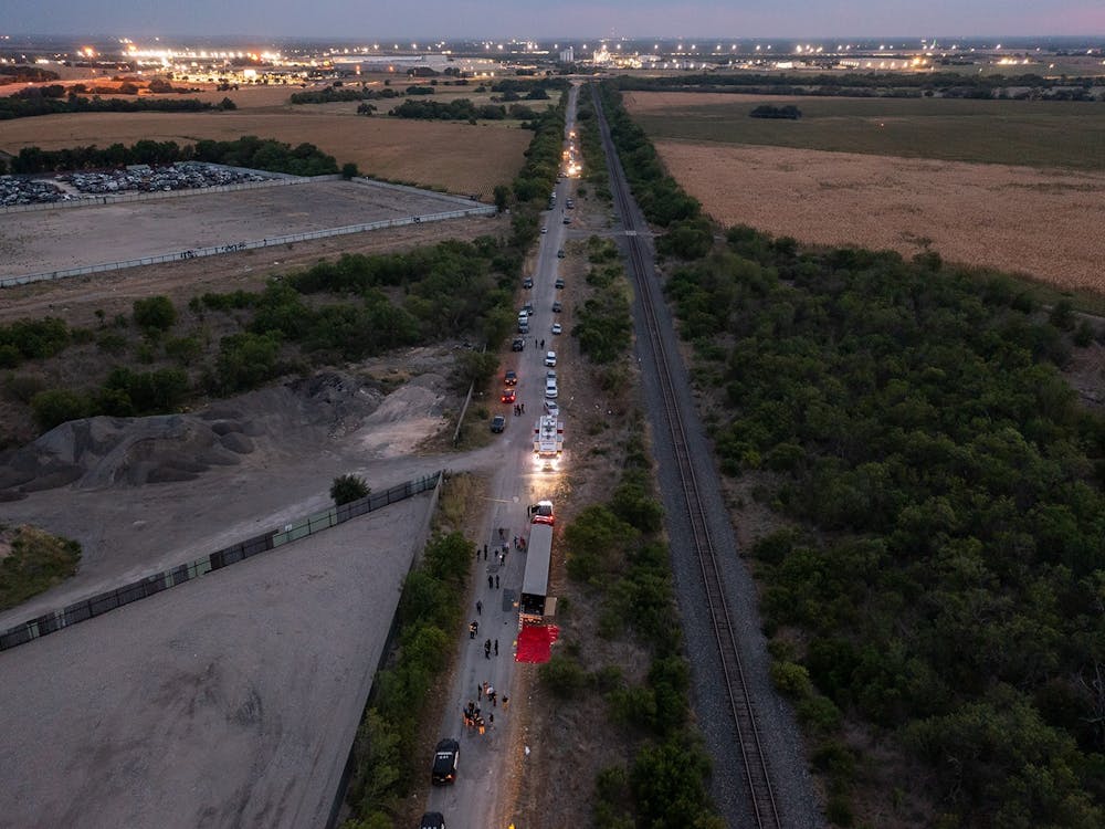 In this aerial view, members of law enforcement investigate a tractor trailer on June 27, 2022, in San Antonio, Texas. According to reports, at least 46 people, who are believed migrant workers from Mexico, were found dead in an abandoned tractor trailer. Over a dozen victims were found alive, suffering from heat stroke and taken to local hospitals. (Jordan Vonderhaar/Getty Images/TNS)