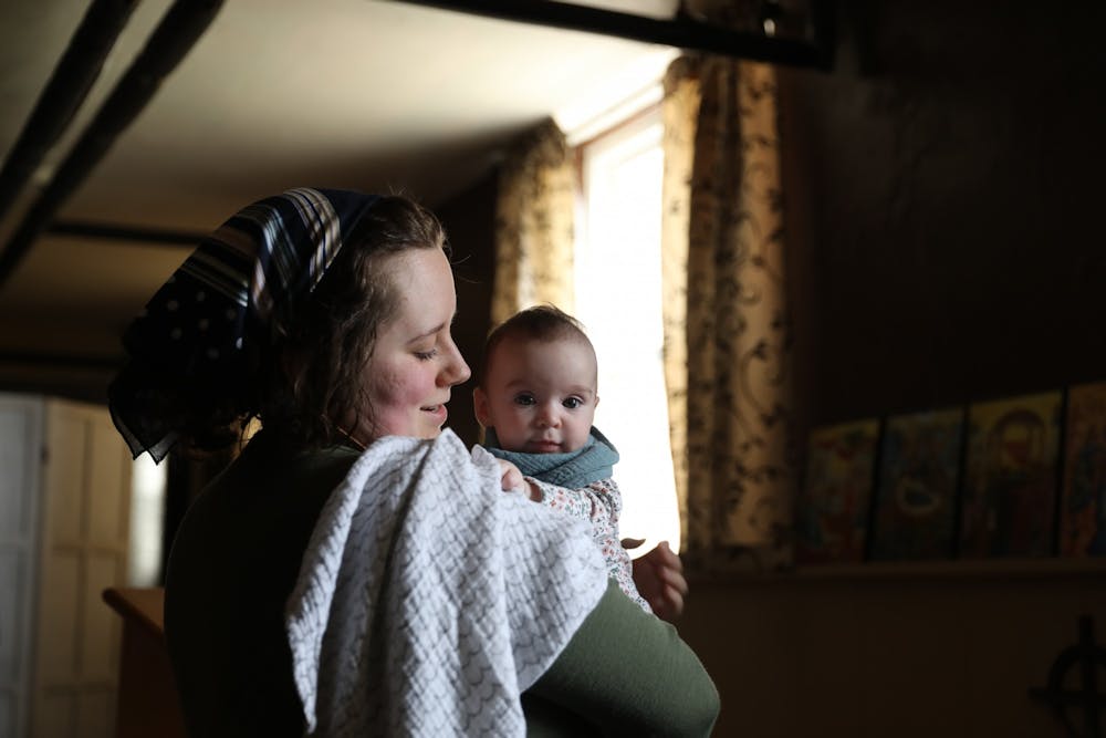 Emily Wilson holds her daughter, Ada, before a service April 4 in the basement of Urban Light Community Church. Wilson's Patron Saint, or personal Guardian is Cecilia of Rome. Rylan Capper, DN 