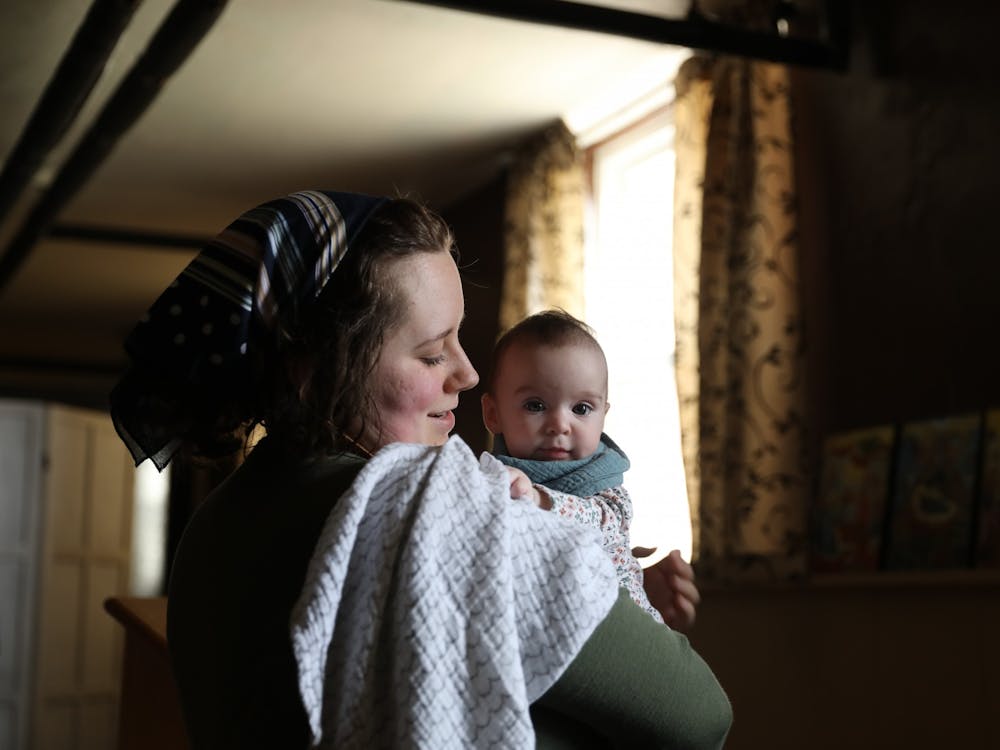 Emily Wilson holds her daughter, Ada, before a service April 4 in the basement of Urban Light Community Church. Wilson's Patron Saint, or personal Guardian is Cecilia of Rome. Rylan Capper, DN 