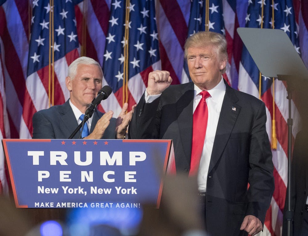 President-elect Donald Trump pumps his fist, with running mate Mike Pence standing by, following a speech to his supporters after winning the election at  the Election Night Party at the Hilton Midtown Hotel in New York City on Wednesday, Nov. 9, 2016. (J. Conrad Williams Jr./Newsday/TNS)