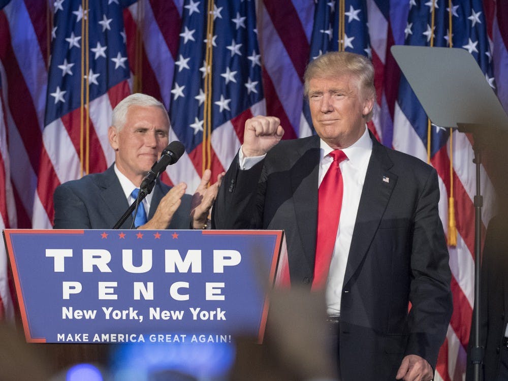 President-elect Donald Trump pumps his fist, with running mate Mike Pence standing by, following a speech to his supporters after winning the election at the Election Night Party at the Hilton Midtown Hotel in New York City on Wednesday, Nov. 9, 2016. (J. Conrad Williams Jr./Newsday/TNS)